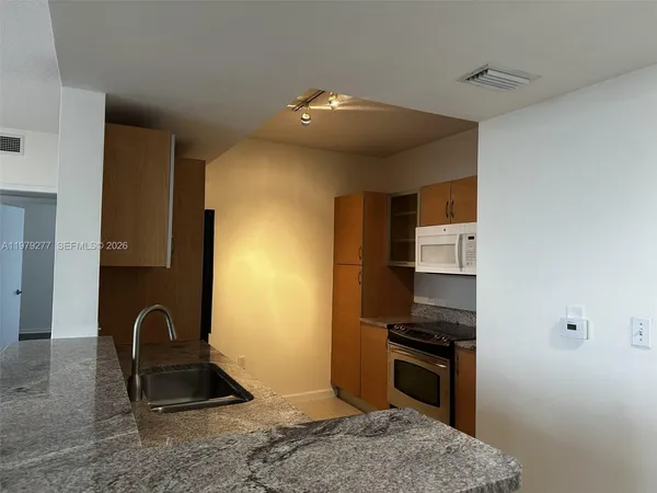 a kitchen with stainless steel appliances granite countertop a stove top oven a sink and dishwasher