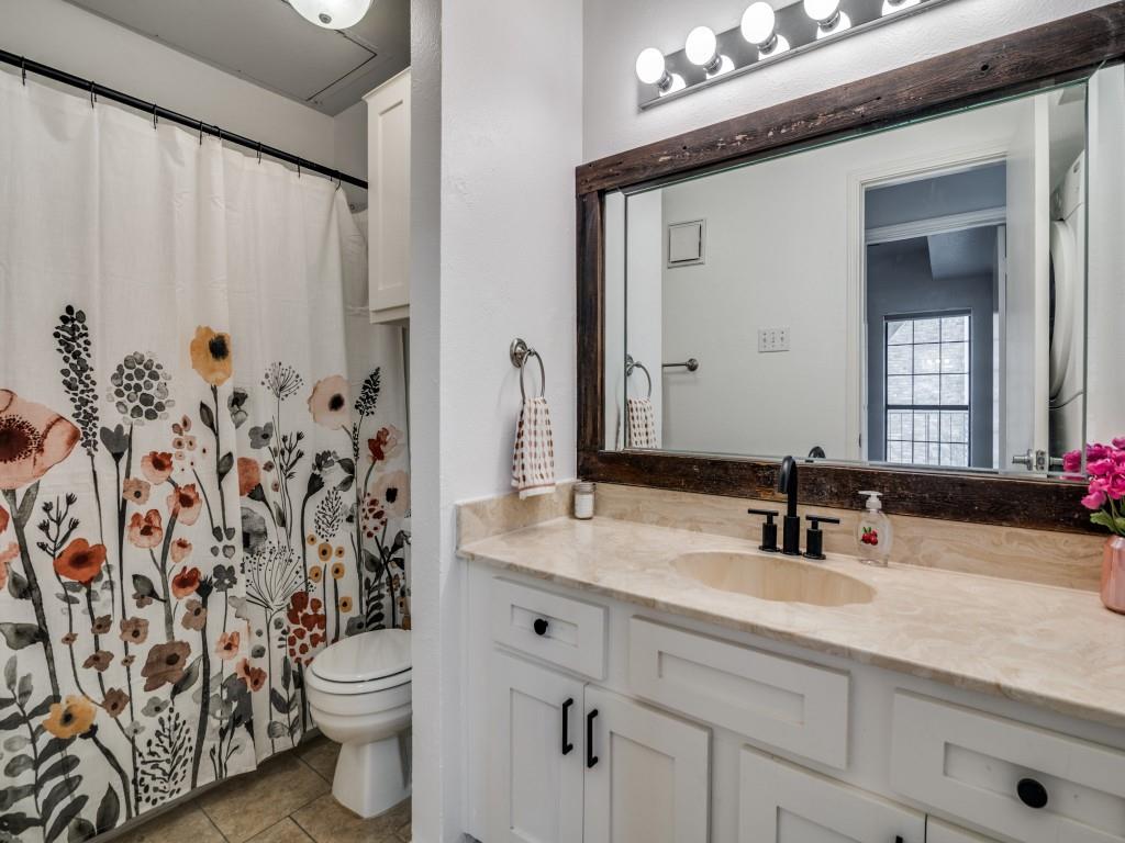4434 Point Boulevard, Unit 208 Garland, TX 75043 - Photo 13 of 28 a bathroom with a granite countertop sink a toilet and a mirror