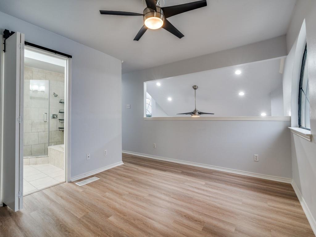 4434 Point Boulevard, Unit 208 Garland, TX 75043 - Photo 20 of 28 an empty room with wooden floor a ceiling fan and windows