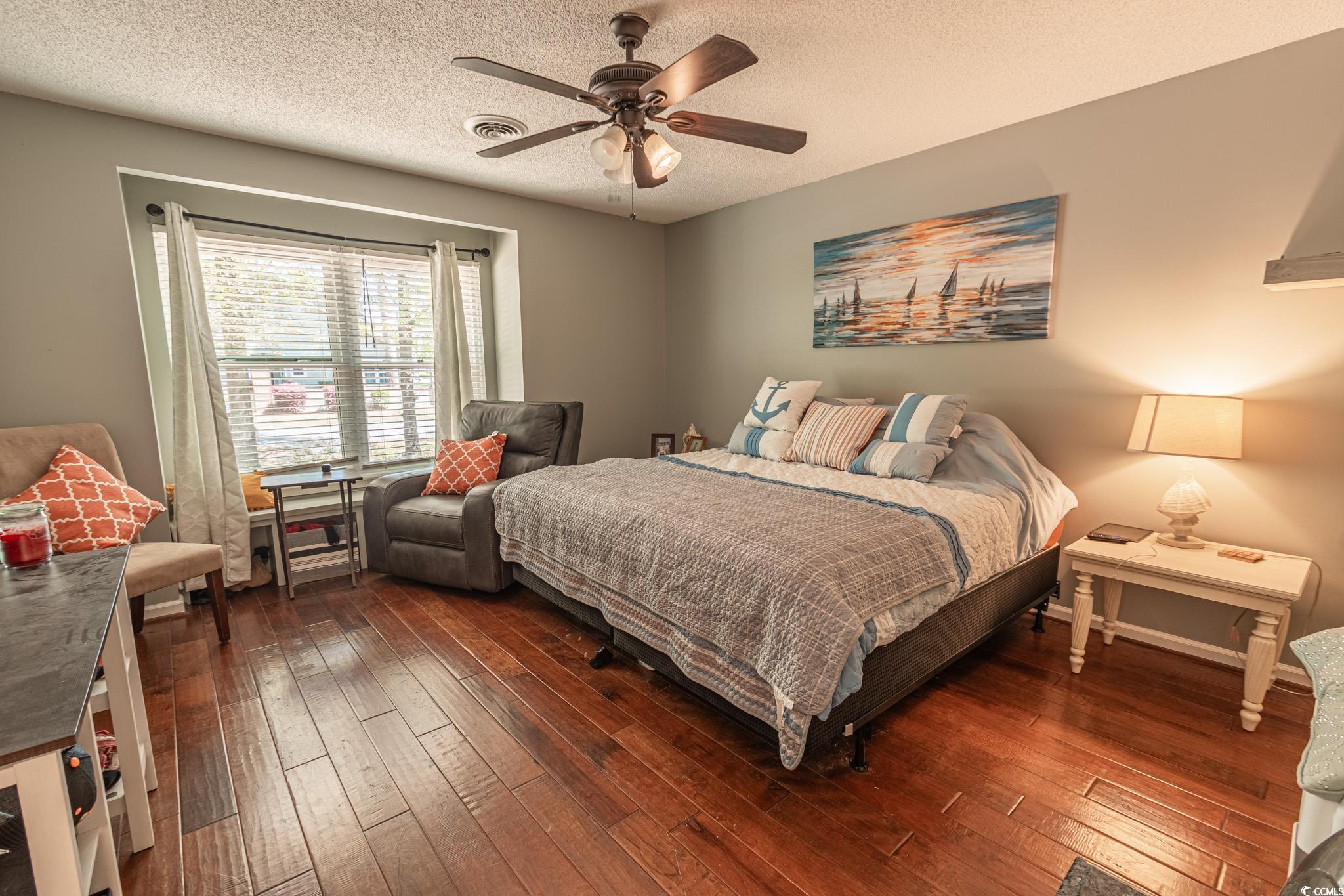 675 Mariner Avenue Murrells Inlet, SC 29576 - Photo 11 of 27 Bedroom with a textured ceiling, dark wood-style flooring, ceiling fan, and visible vents