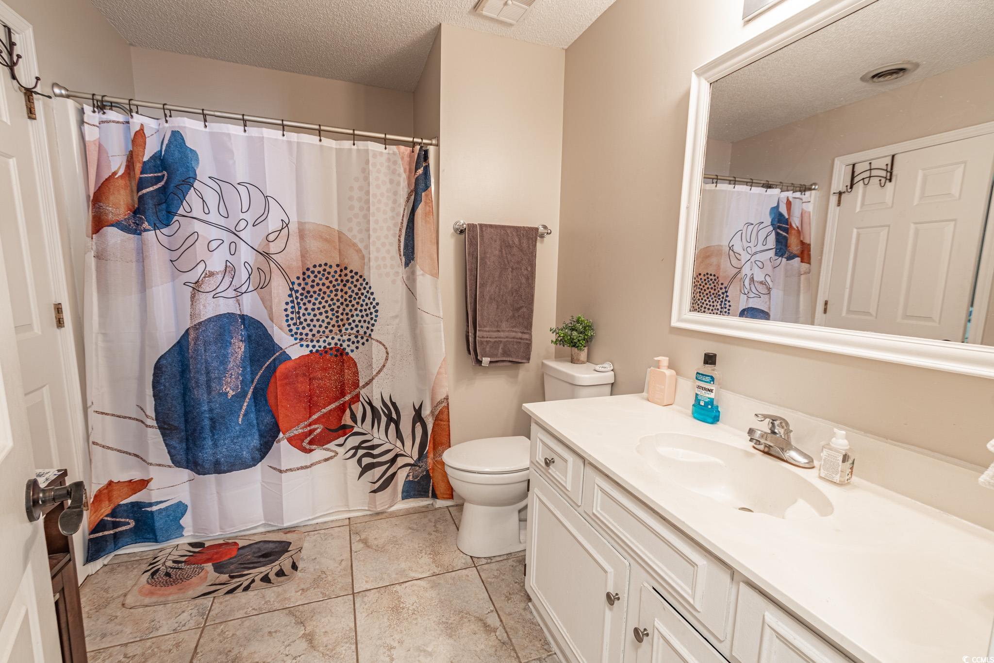 675 Mariner Avenue Murrells Inlet, SC 29576 - Photo 12 of 27 Bathroom with vanity, tile patterned flooring, a textured ceiling, toilet, and visible vents