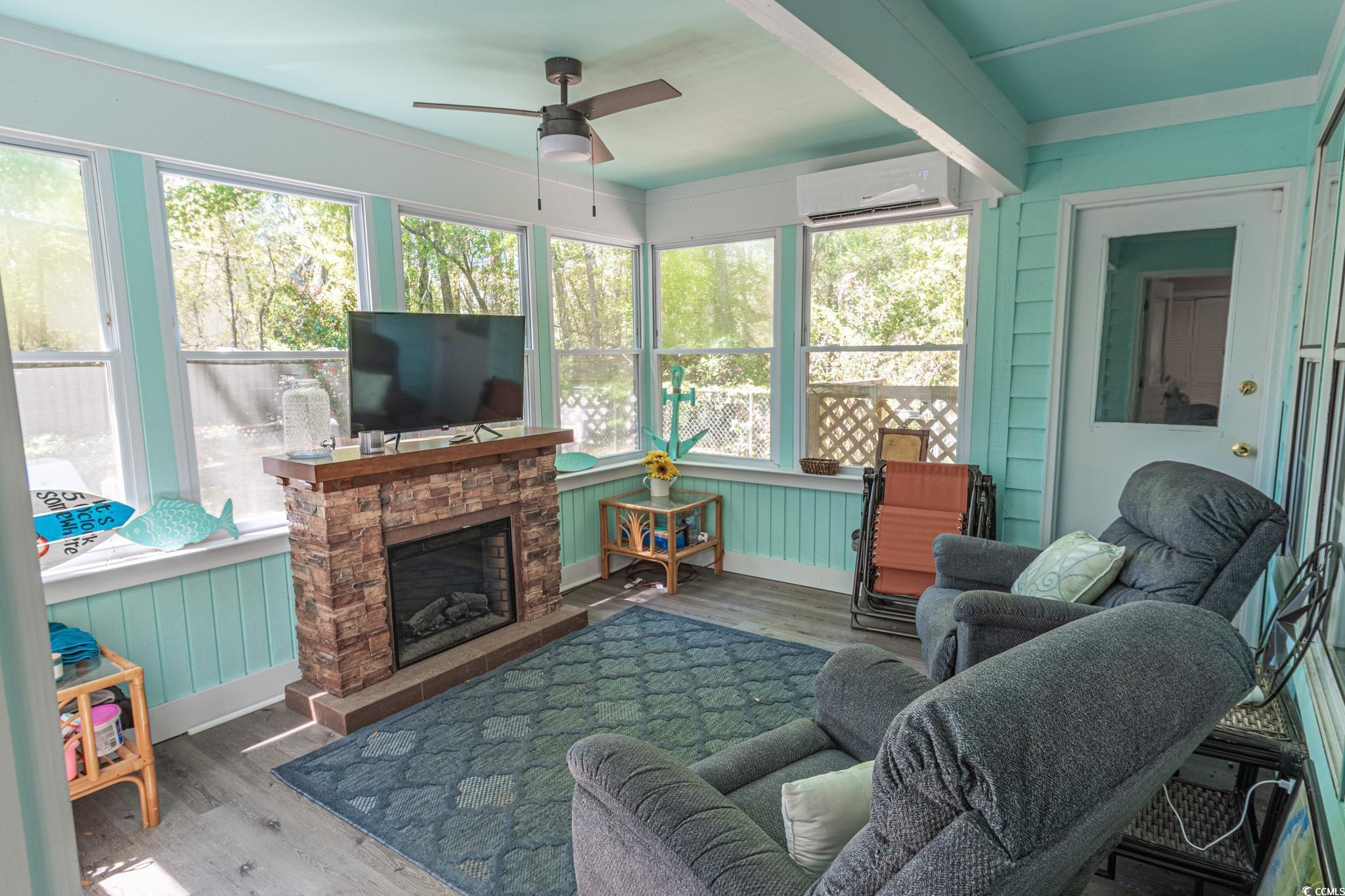 675 Mariner Avenue Murrells Inlet, SC 29576 - Photo 14 of 27 Sunroom with a wall mounted air conditioner, a ceiling fan, and a stone fireplace