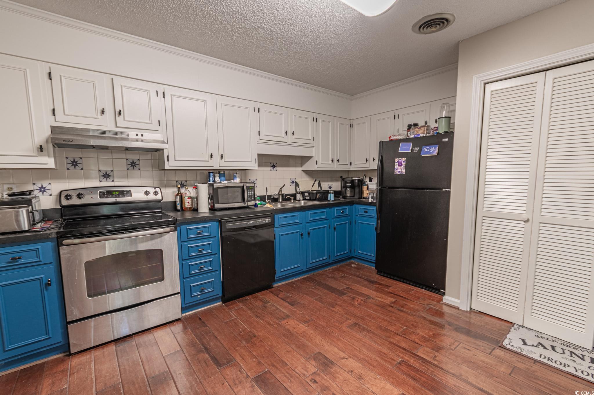 675 Mariner Avenue Murrells Inlet, SC 29576 - Photo 6 of 27 Kitchen with visible vents, black appliances, under cabinet range hood, blue cabinets, and dark countertops