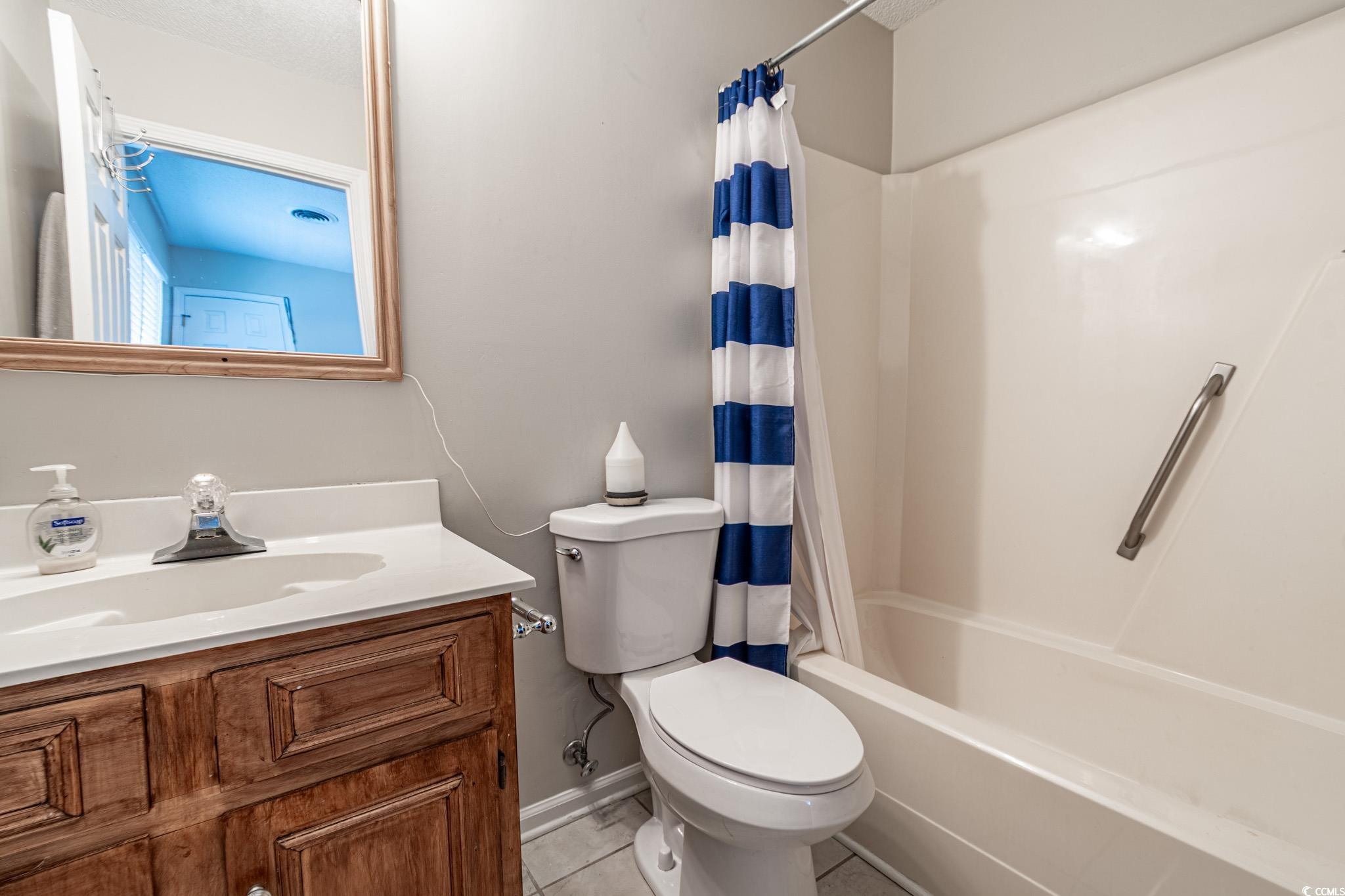 675 Mariner Avenue Murrells Inlet, SC 29576 - Photo 9 of 27 Bathroom with baseboards, shower / bath combination with curtain, toilet, vanity, and tile patterned floors