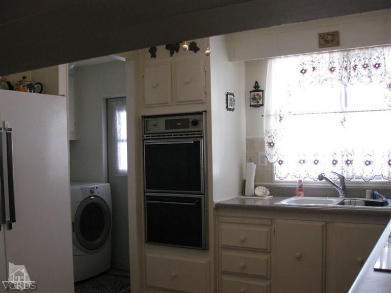 6480 Katherine Road, Unit 10 Simi Valley, CA 93063 - Photo 11 of 20 a kitchen with a refrigerator and cabinets