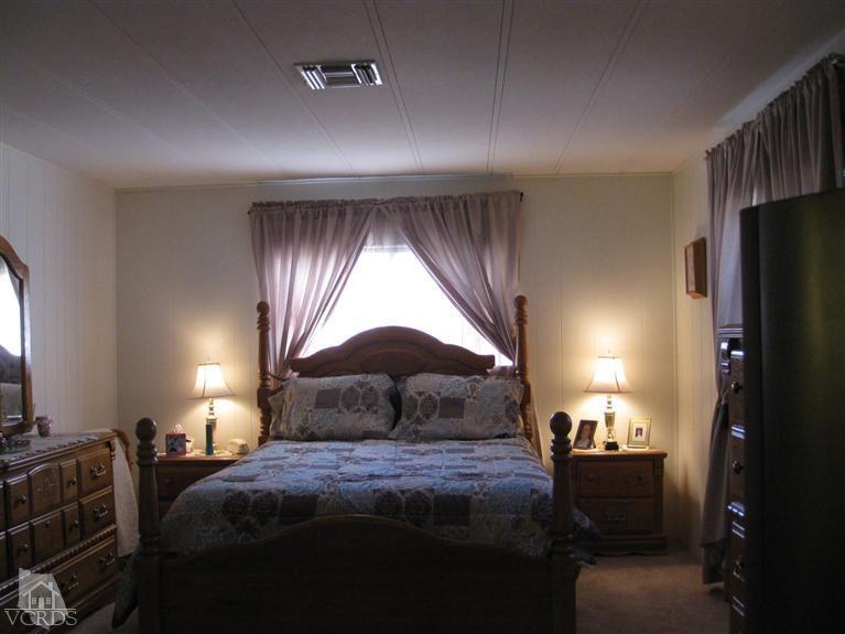 6480 Katherine Road, Unit 10 Simi Valley, CA 93063 - Photo 16 of 20 a bedroom with a bed and a lamp with window