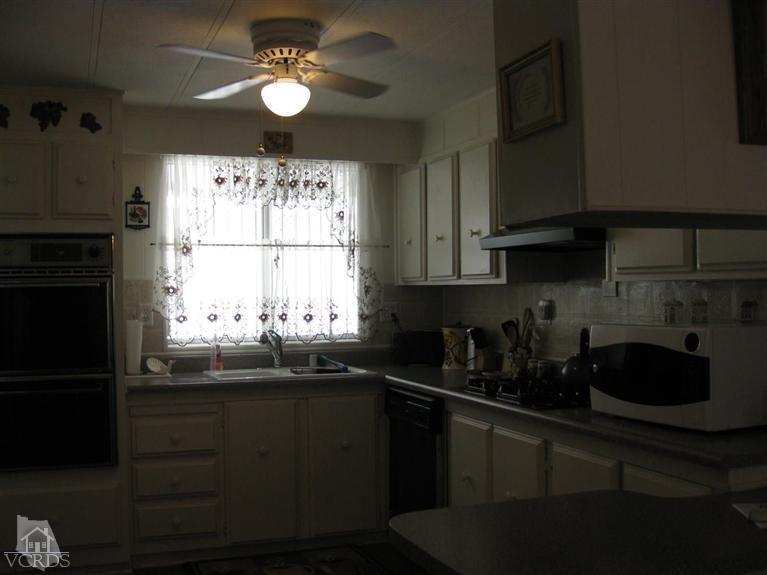 6480 Katherine Road, Unit 10 Simi Valley, CA 93063 - Photo 10 of 20 a kitchen with a sink a window and cabinets