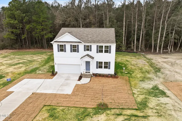 a view of a white house with a yard