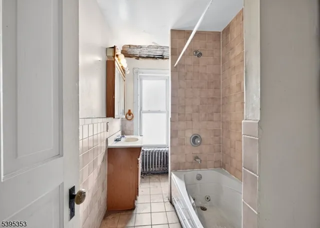 a bathroom with a tub sink and mirror