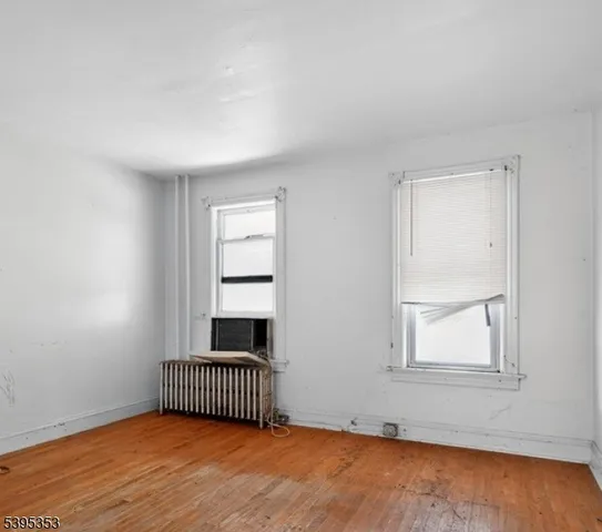 an empty room with wooden floor and a window