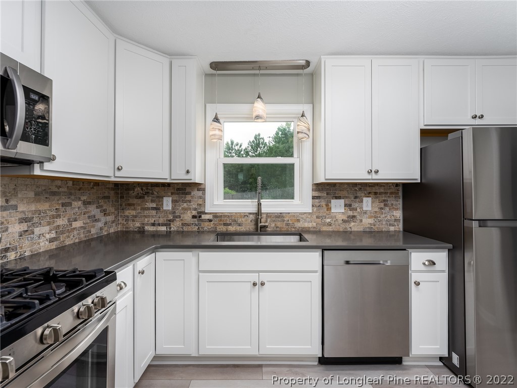 452 Saddle Ridge Road Fayetteville, NC 28311 - Photo 10 of 37 a kitchen with granite countertop a sink stainless steel appliances and cabinets