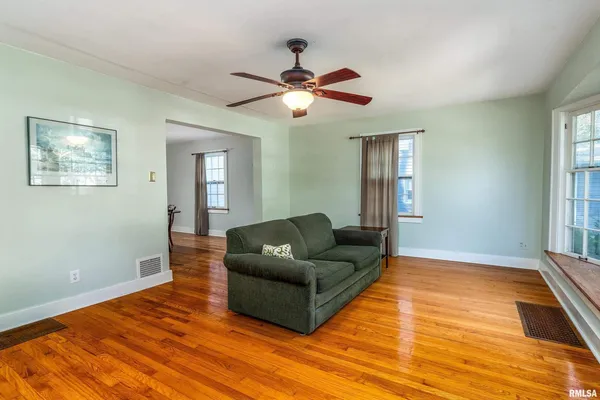a living room with furniture and a ceiling fan