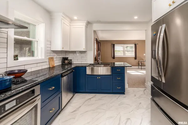 a kitchen with stainless steel appliances granite countertop a refrigerator and a sink