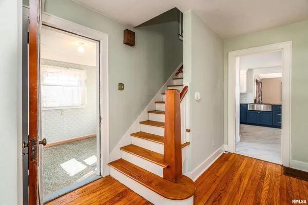 a view of an entryway with wooden floor and staircase