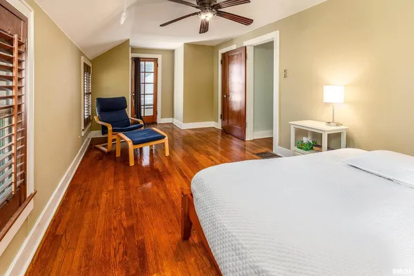 a bedroom with a bed and wooden floor