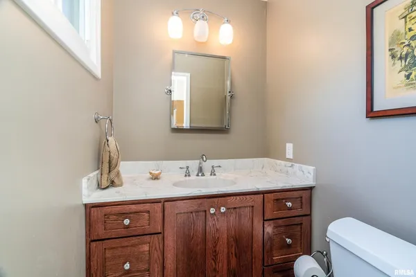 a bathroom with a granite countertop sink toilet and mirror