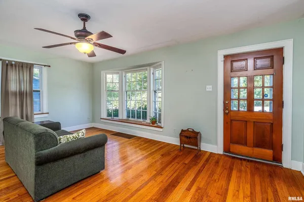 a living room with furniture and a wooden floor