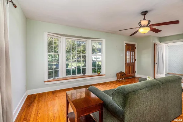 a living room with a bed furniture and a large window