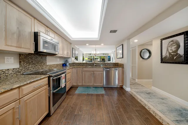 a kitchen with stainless steel appliances granite countertop a refrigerator and a stove top oven