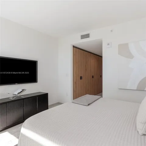 a spacious bedroom with a large bed and a large window