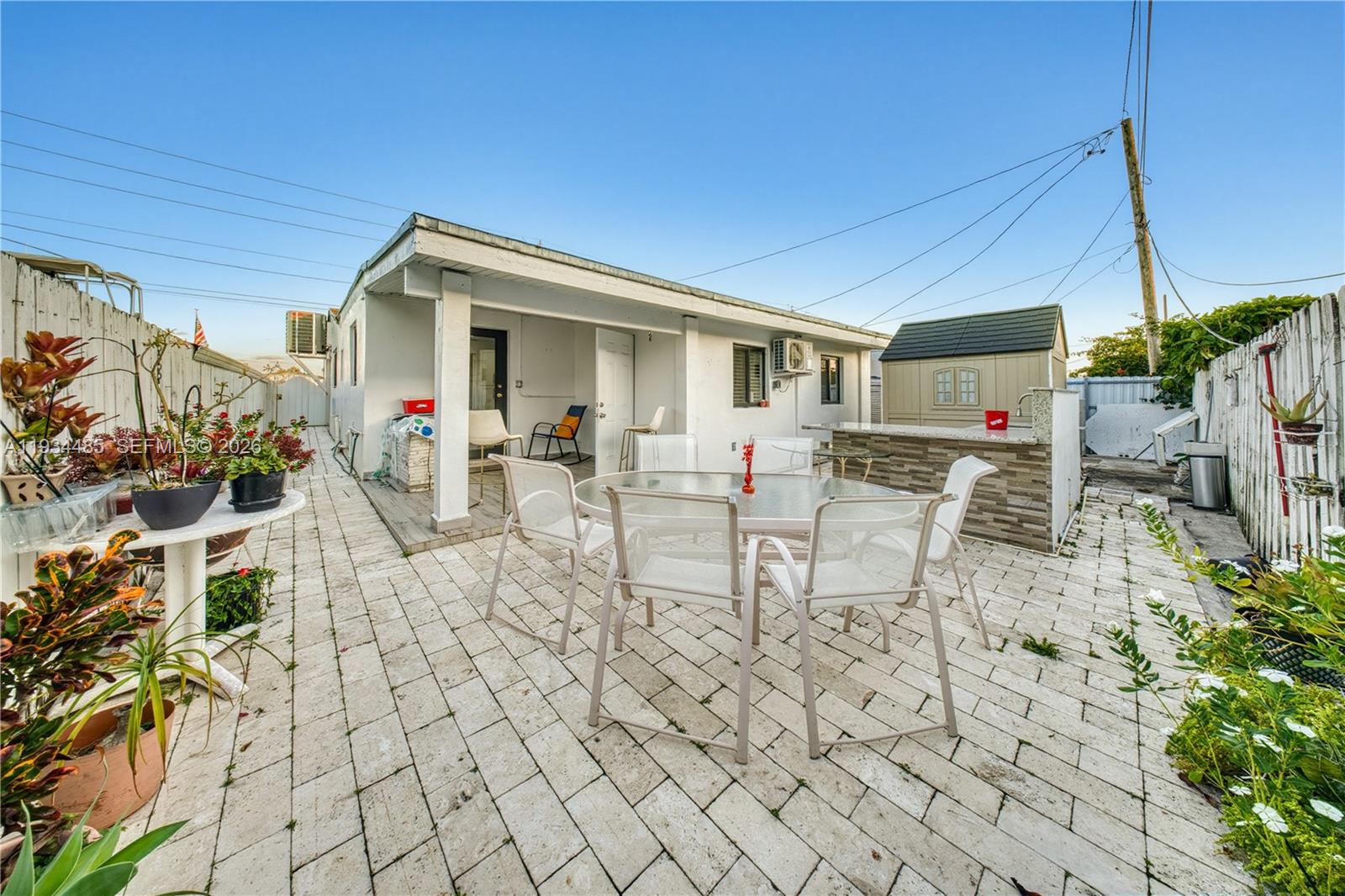 3640 Southwest 92nd Avenue Miami, FL 33165 - Photo 26 of 30 a view of a patio with table and chairs potted plants and floor to ceiling window and potted plants