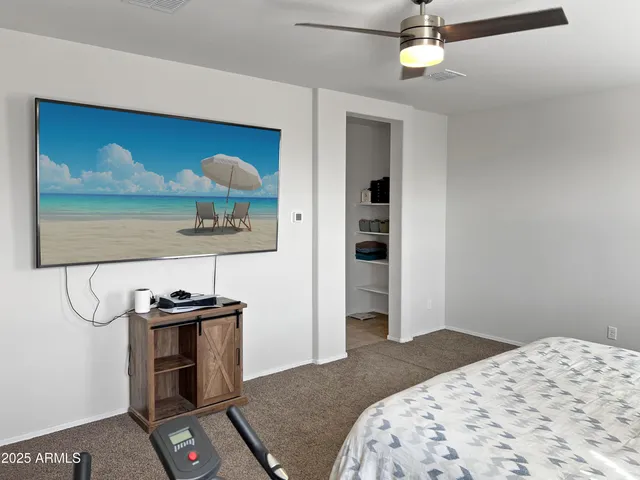 a bedroom with a bed and a flat tv screen on the dresser