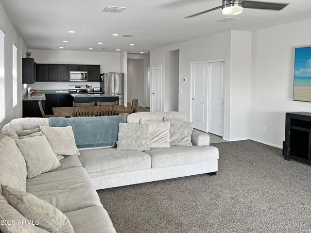 a living room with furniture and kitchen view