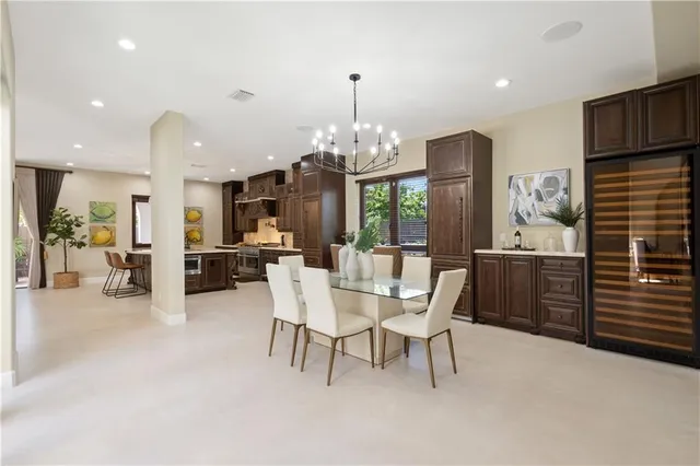 a dining room with furniture a chandelier a kitchen view and a chandelier