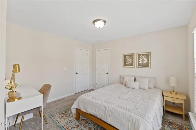 a bedroom with a bed and a chair with the wooden floor