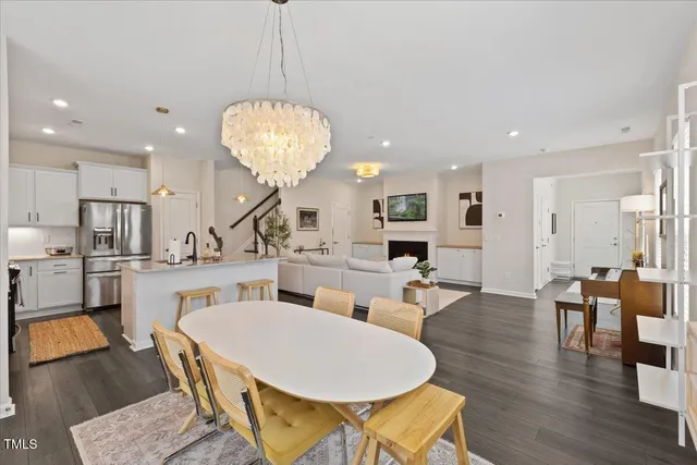 an open kitchen with dining table and wooden floor