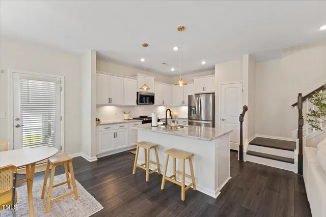 a large kitchen with cabinets table and chairs