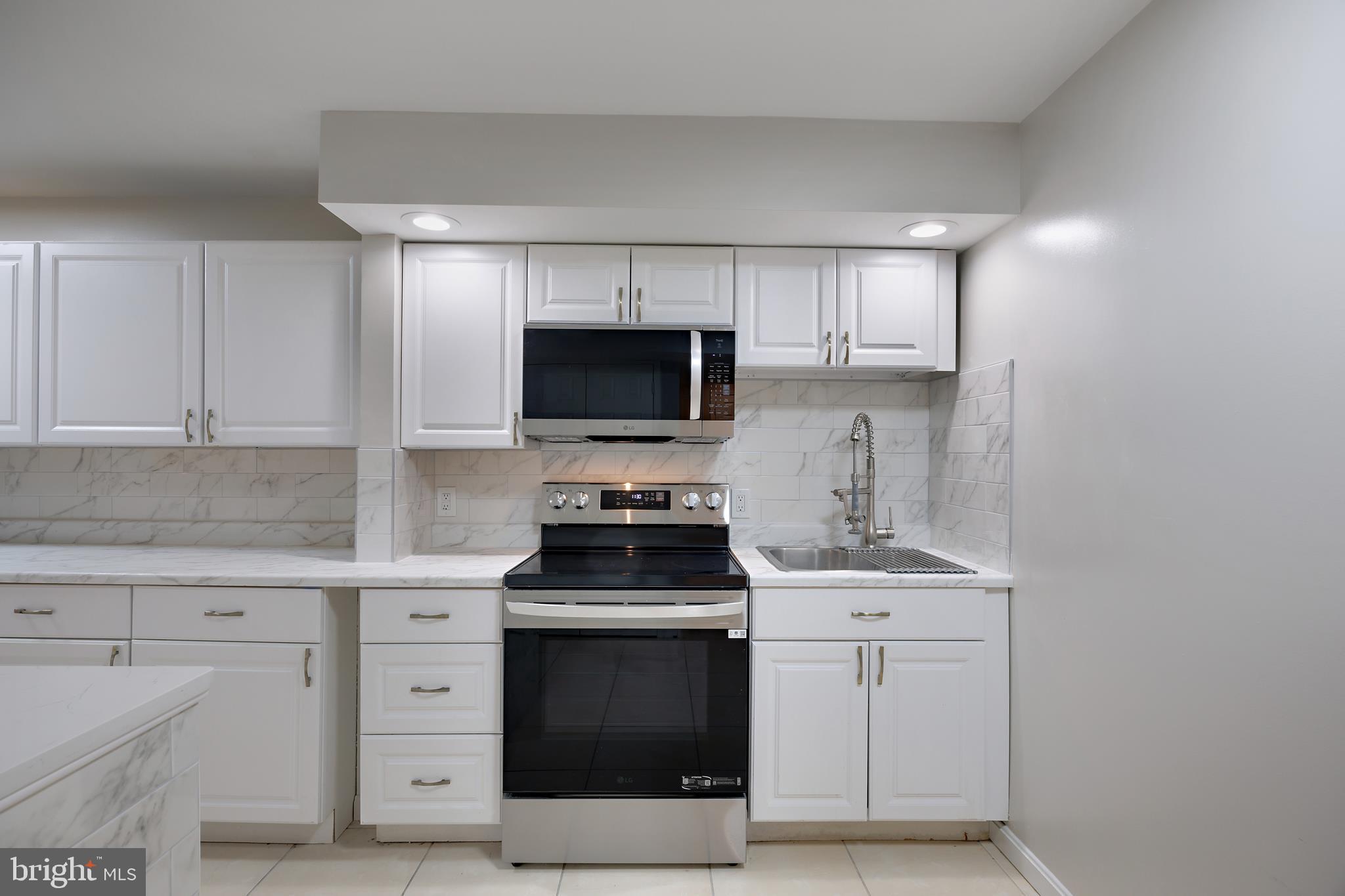 16729 Queen Anne Road Upper Marlboro, MD 20774 - Photo 10 of 29 a kitchen with white cabinets stainless steel appliances and sink