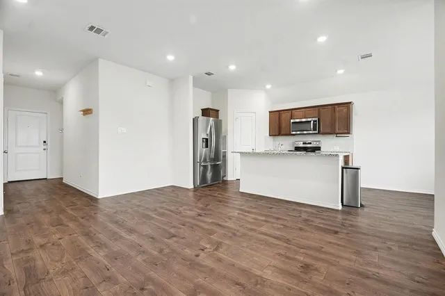 a view of kitchen with kitchen island microwave and refrigerator