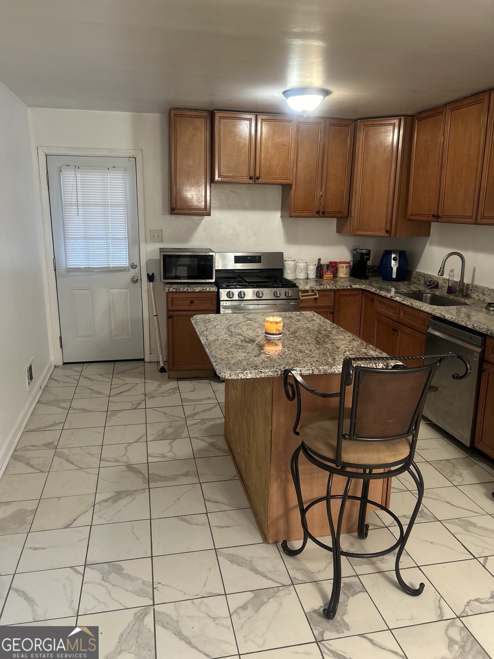 1406 Canterbury Road Griffin, GA 30223 - Photo 10 of 26 a kitchen with stainless steel appliances granite countertop a stove a sink a microwave and a refrigerator