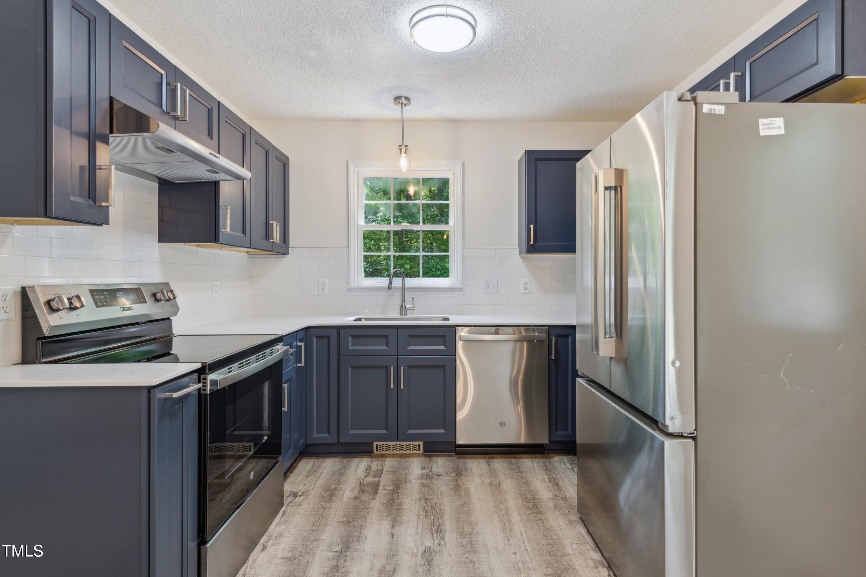 856 Williams-White Road Zebulon, NC 27597 - Photo 17 of 38 a kitchen with stainless steel appliances granite countertop a refrigerator and a sink