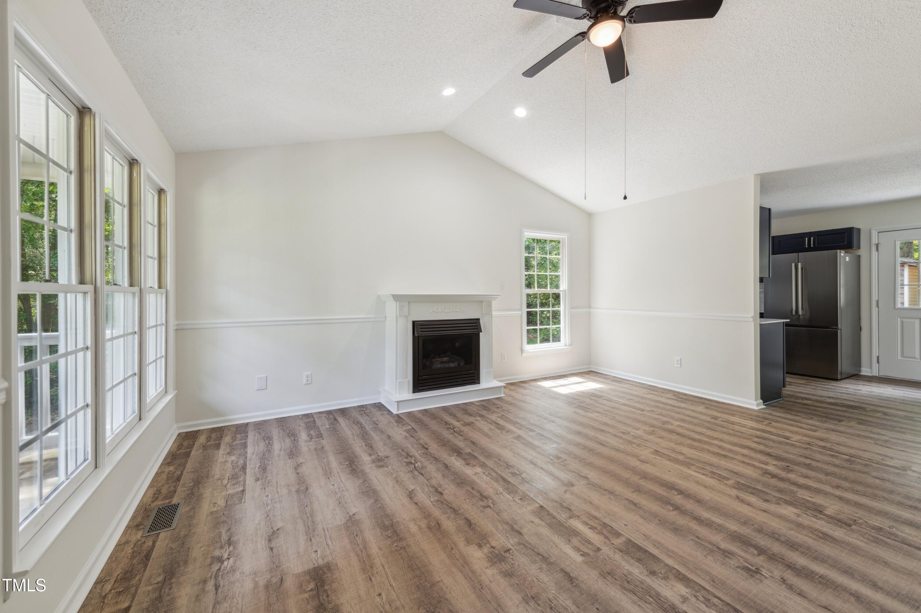856 Williams-White Road Zebulon, NC 27597 - Photo 18 of 38 wooden floor fireplace and windows in an empty room
