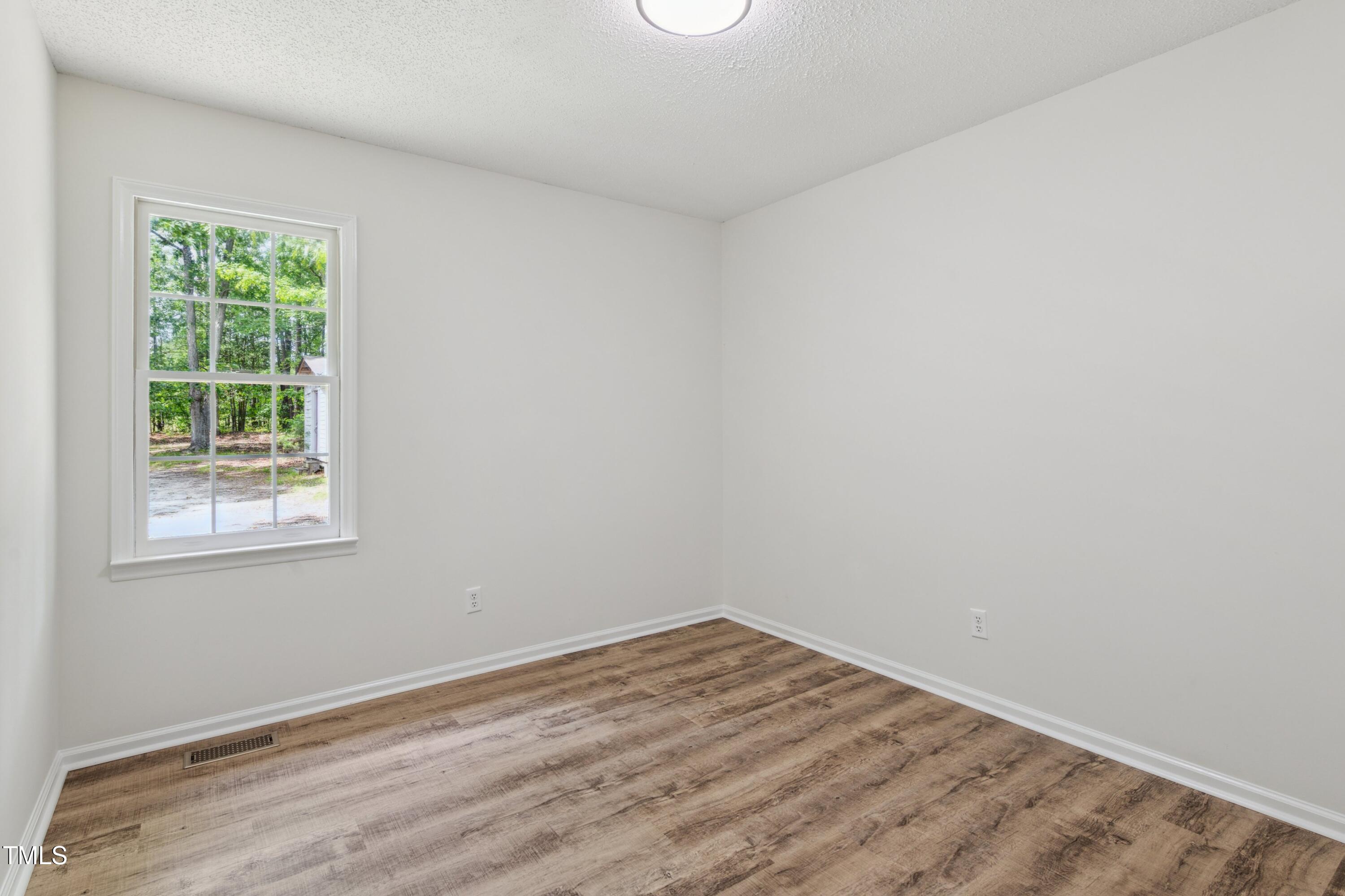 856 Williams-White Road Zebulon, NC 27597 - Photo 19 of 38 an empty room with a window