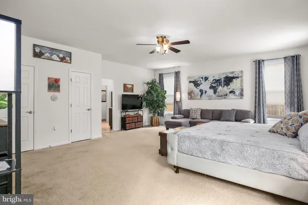 a spacious bedroom with a bed a table and chair