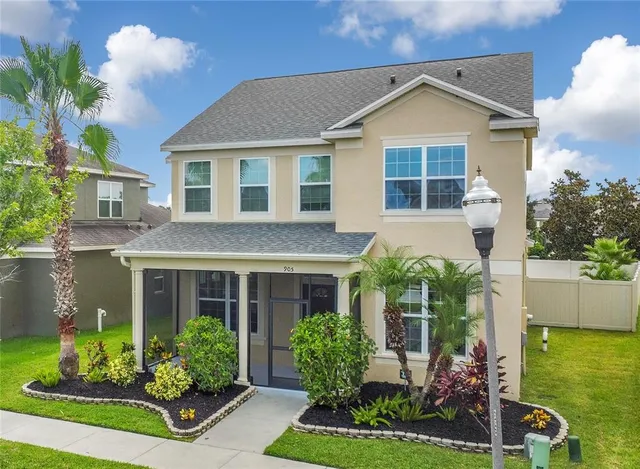 a front view of a house with a yard and potted plants