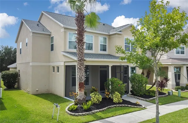 a front view of a house with a yard and potted plants