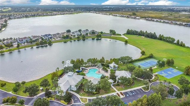 an aerial view of residential houses with outdoor space and lake view