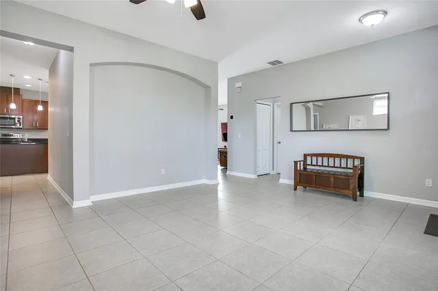 a living room with furniture kitchen view and a chandelier