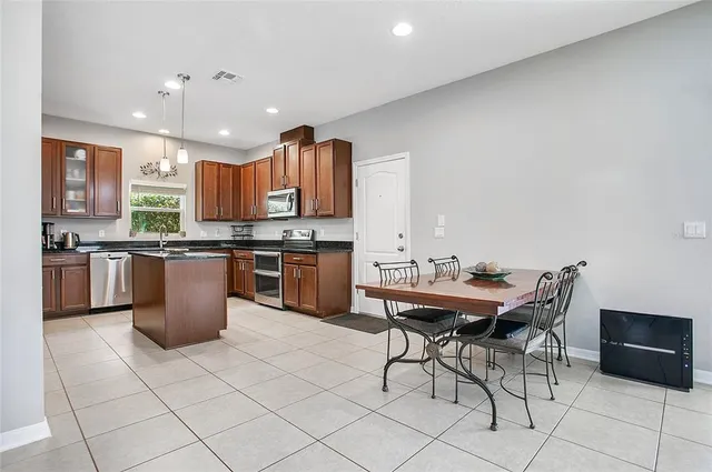 a room with stainless steel appliances furniture and a dining table