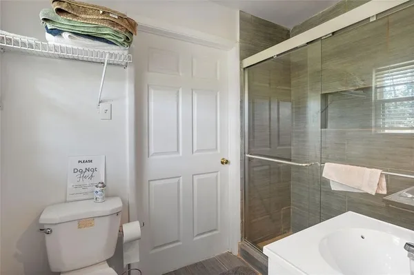 a bathroom with a sink a toilet and shower