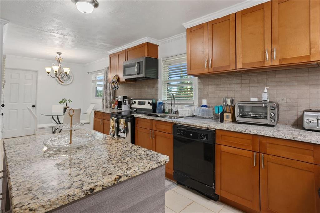 3501 Wesley Chapel Road Decatur, GA 30034 - Photo 4 of 20 a kitchen with stainless steel appliances granite countertop a sink dishwasher stove top oven and cabinets with wooden floor