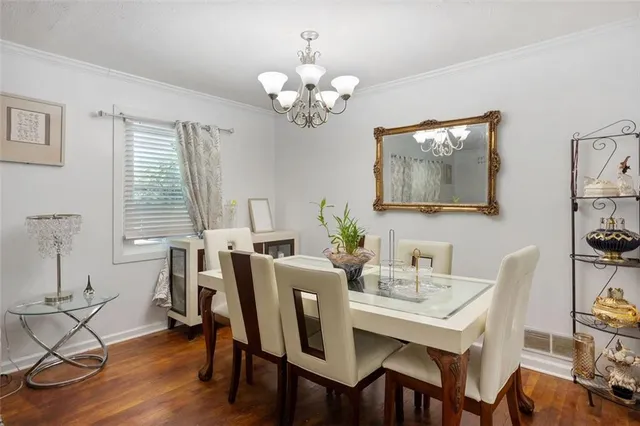 a view of a dining room with furniture wooden floor and a chandelier