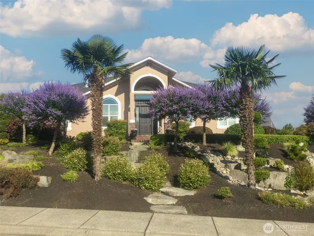 a front view of a house with a yard and garden