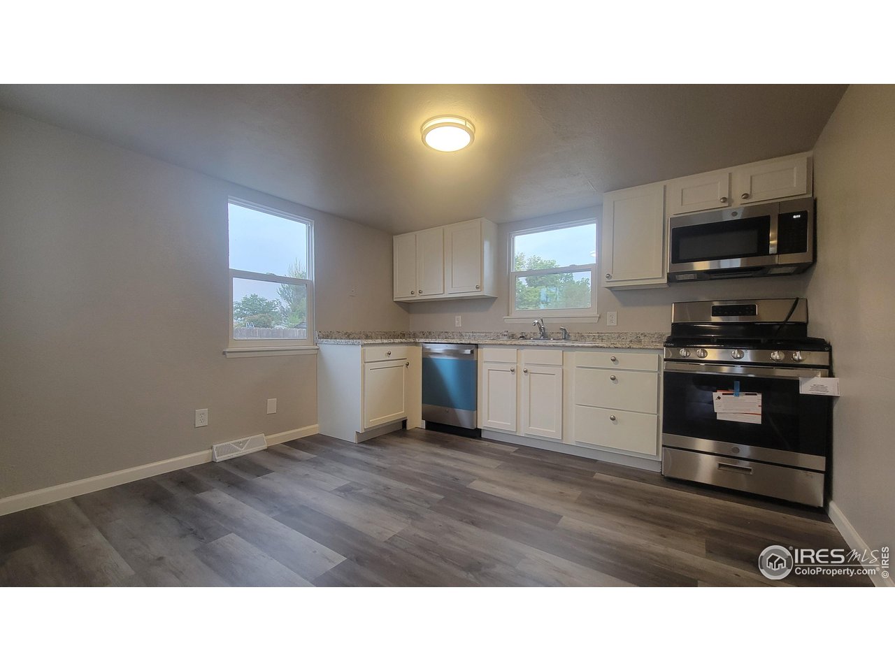 109 4th Street Gilcrest, CO 80623 - Photo 4 of 22 a kitchen with stainless steel appliances kitchen island granite countertop a sink window and cabinets