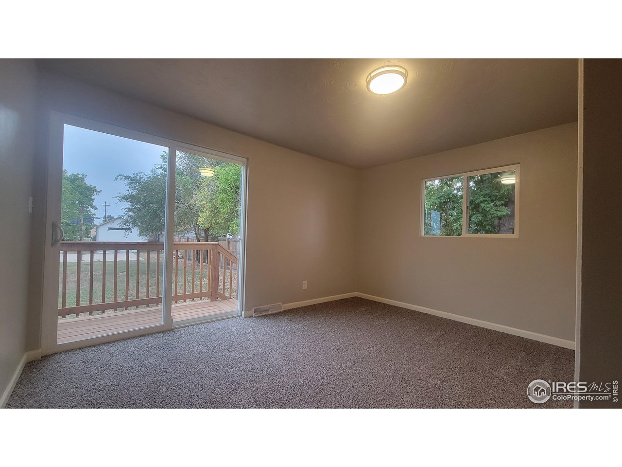 109 4th Street Gilcrest, CO 80623 - Photo 8 of 22 a open hall with a floor to ceiling window and a flat screen tv