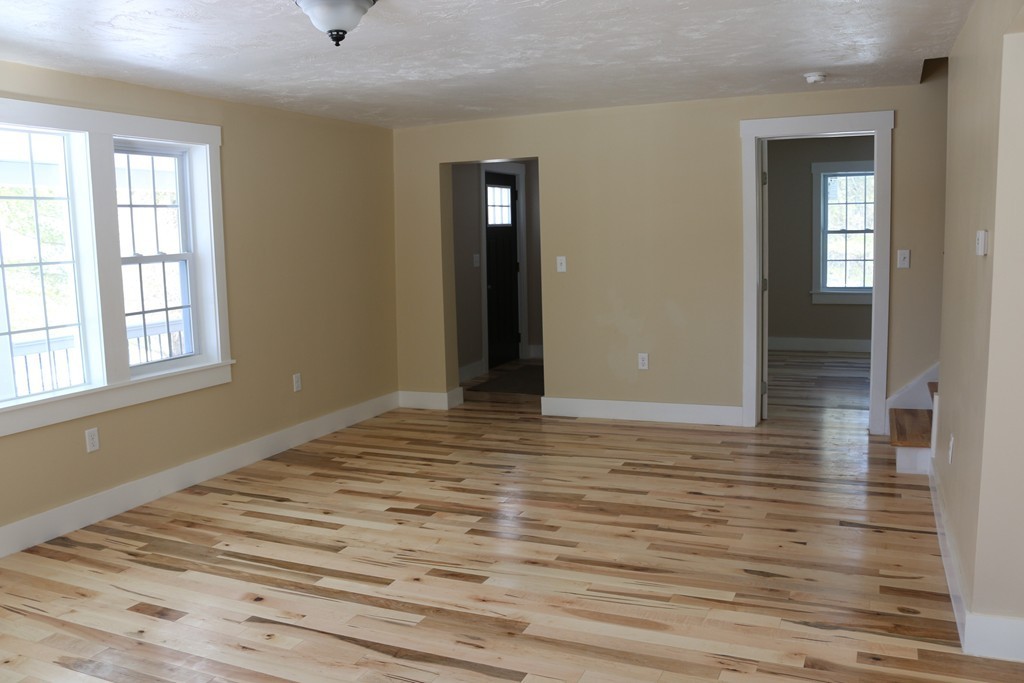 181 Westboro Road Upton, MA 01568 - Photo 2 of 15 a view of an empty room with wooden floor and a window
